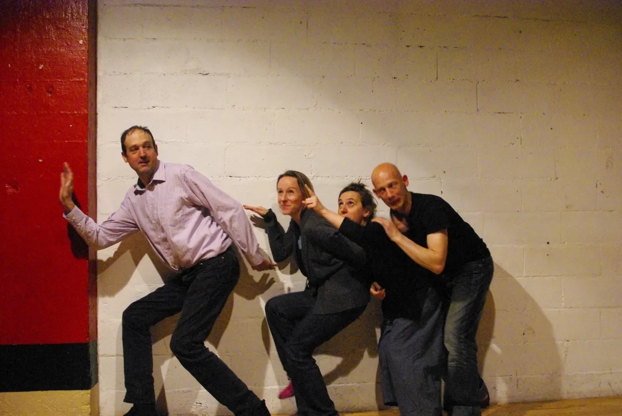 Atelier d'improvisation : quatre comédiens en chaîne, penchés dans le même élan - Freely Cook
